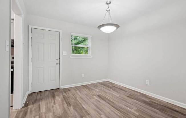 A room with a white door and a window with blinds.