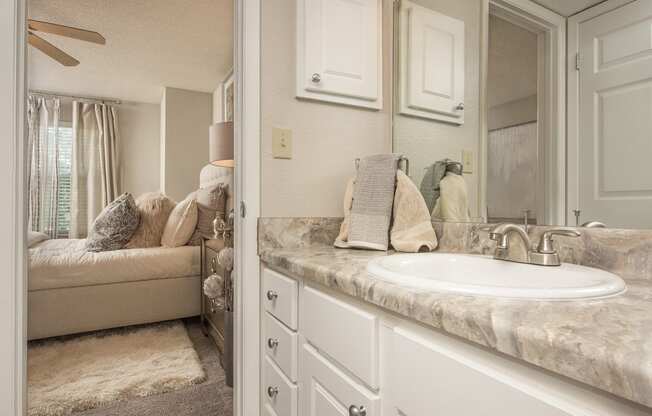 a bathroom with a sink and a mirror and a couch at Highland Ridge Apartments, Kansas