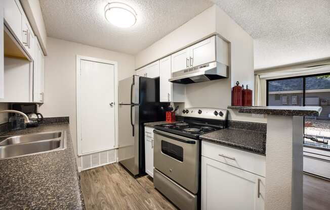 Kitchen with white cabinetry and black appliances at Windmill Apartments, Colorado, 80916