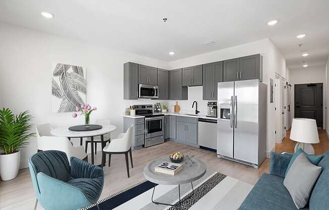 a kitchen and living room with stainless steel appliances and a table