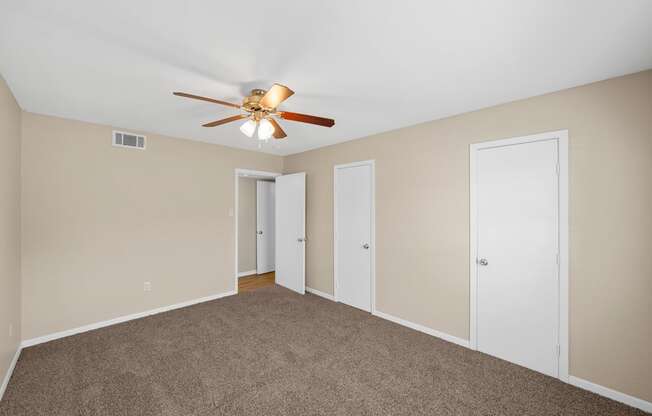 an empty living room with carpet and a ceiling fan at Brookside Apartments, Hewitt, Texas