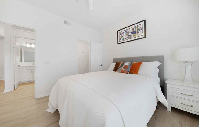 A bedroom with a large bed and a white dresser.