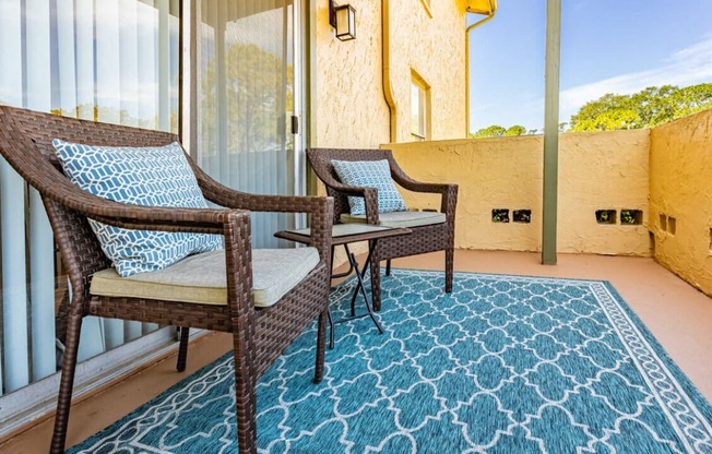 a balcony with two chairs and a rug