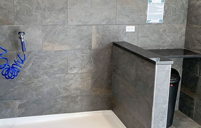 a bathroom with a bath tub and a trash can