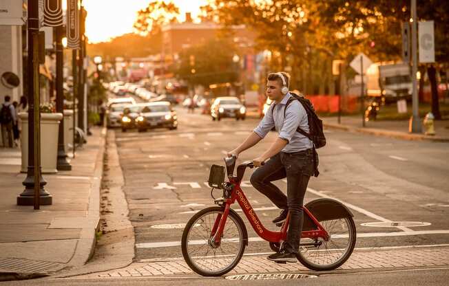 a man riding a bike on a city street at The Acadia at Metropolitan Park, Arlington, VA