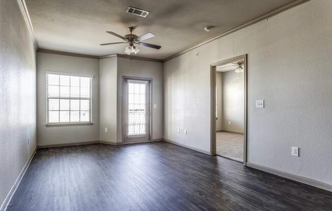 an empty living room with a ceiling fan