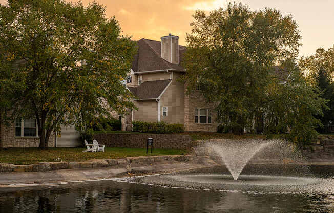 A house with a fountain in front of it.