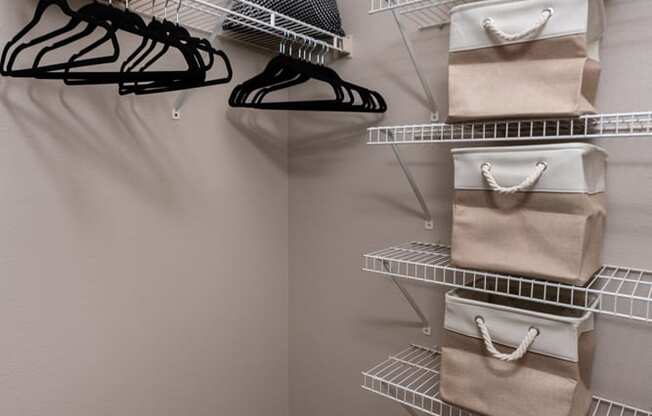 a walk in closet with bags and shelves
