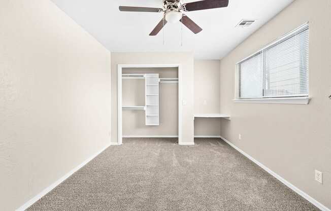 an empty room with a ceiling fan and a closet at Diamond Ridge Townhomes, Oklahoma