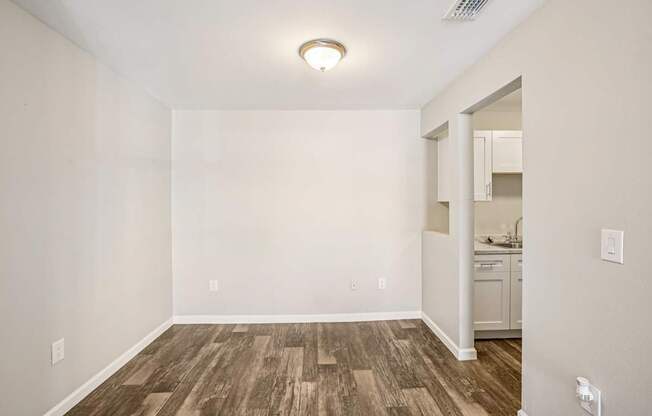A room with wooden flooring and white walls.