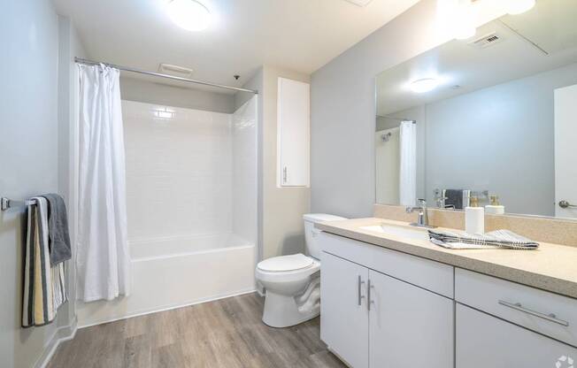 A white bathroom with a toilet, sink, and shower.