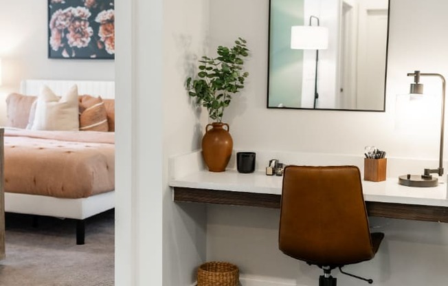 a desk with a mirror and a chair in a bedroom