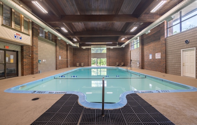 A large indoor pool with a sign that says