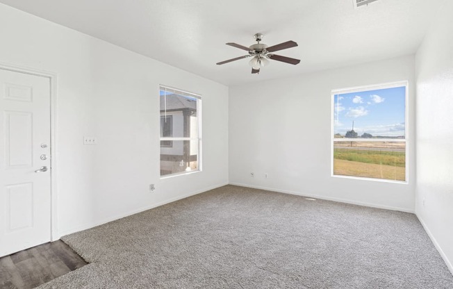 Affordable Apartments in Austin, TX for Rent- Huntington Meadows-  A room with a ceiling fan and a window showing a view of the outside.