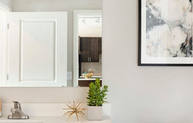 A white toilet sits next to a sink with a plant on top of it.