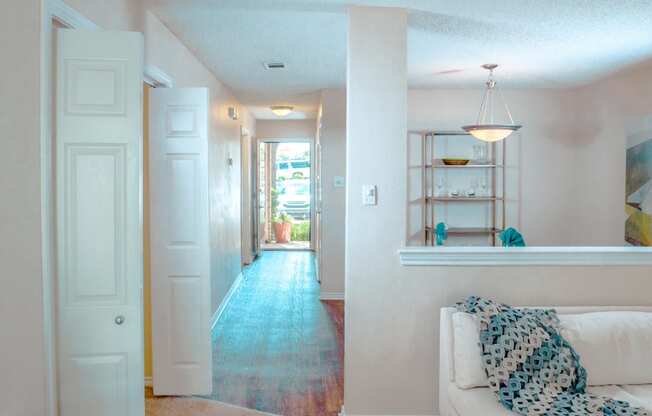 Model view of living room and a hallway to entrance at Chisholm Place Apartments in Plano, TX