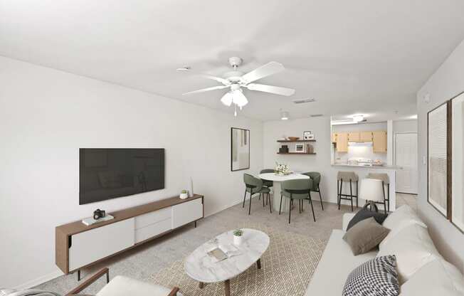 Virtually staged living area facing the kitchen with a white couch and television mounted on the wall