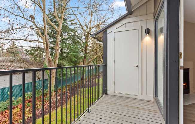 A balcony with a white door and a black railing.
