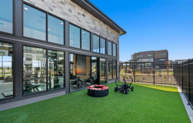 a yard with lawn bikes and a building with large windows