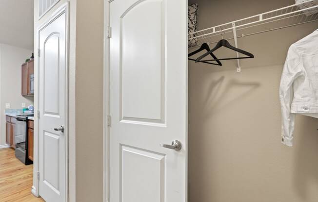 a walk in closet with a white door and a hanger on the wall