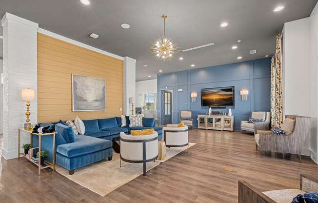 a living room with blue couches and chairs and a tv