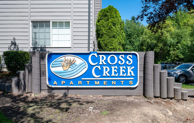 a sign in front of a building that says cross creek apartments