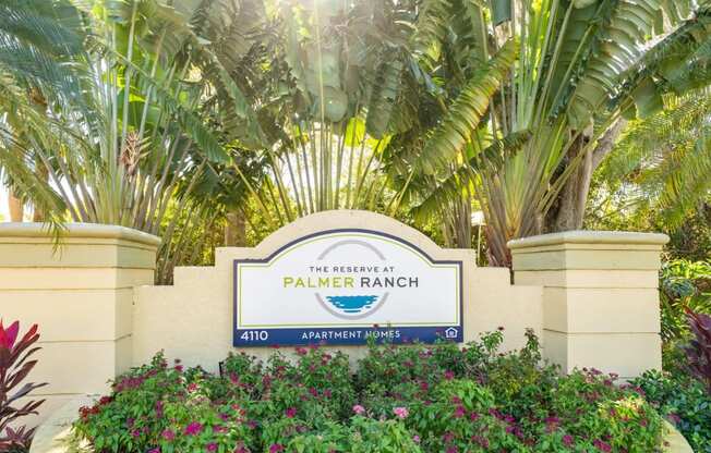 a sign that says palmer ranch with palm trees in the background