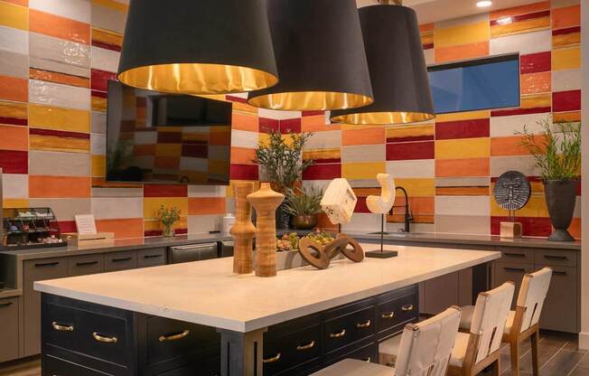 the kitchen has a large island with chairs and two large hanging lights at Weylyn Luxury Apartments, Laveen, AZ, 85339