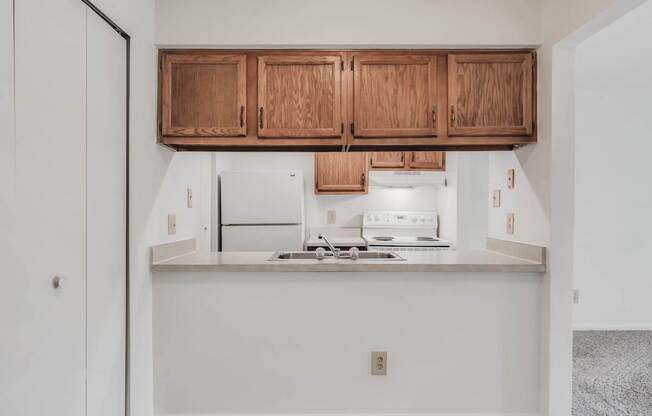 A kitchen with wooden cabinets and a stainless steel stove top.