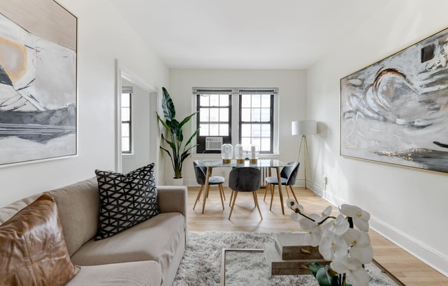 living area with large windows, sofa, coffee table, hardwood floors and view of dining area at the dahlia apartments in washington dc