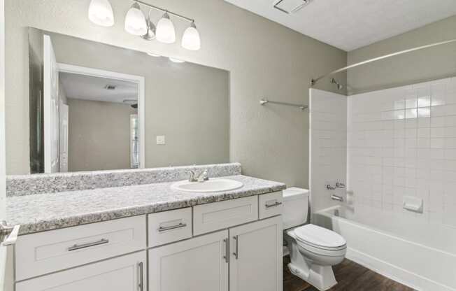 Modern bathroom with a sink, toilet and a shower and ample cabinet space at Oakley Run apartments in Smyrna, GA