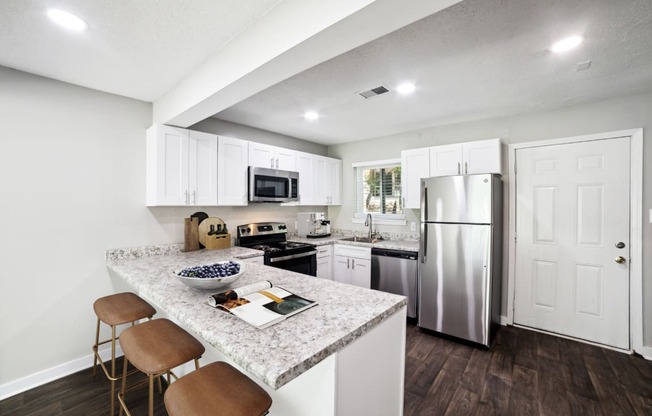 a kitchen with white cabinetry and a granite counter top
