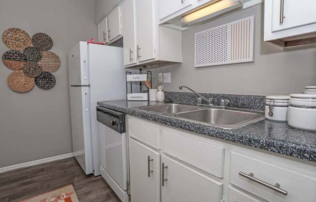 Model kitchen with white cabinets and a white fridge at Maplewood apartments in Shreveport, LA.