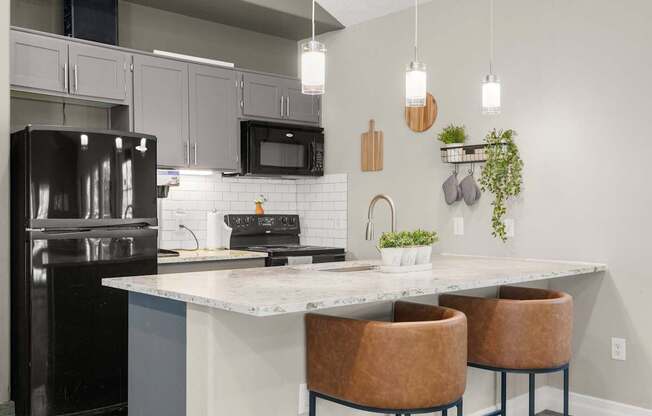 Clubhouse kitchen with a black refrigerator, a white countertop, and brown chairs at Clackamas Trails Apartments, Oregon, 97222
