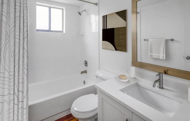 a bathroom with a white sink and toilet and a white bathtub