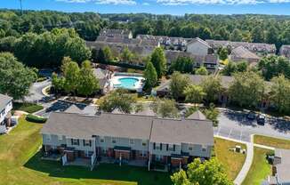 A bird's eye view of a residential area with houses and a swimming pool.