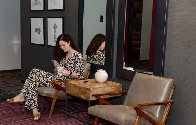 a woman sitting in a chair looking at her phone