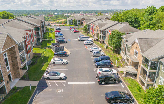 an aerial view of a neighborhood with cars parked on the street