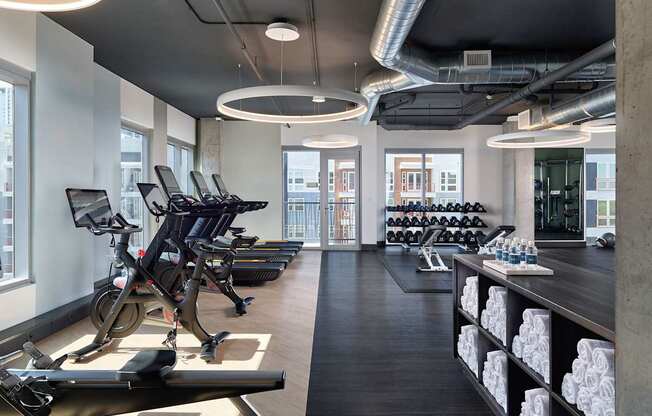 A gym with treadmills, exercise bikes, and weights.