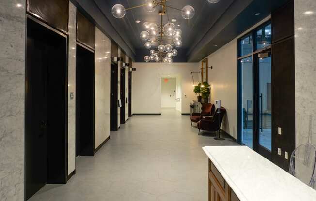 a long hallway with a marble counter top and a row of black doors at The Commonwealth Building, Pittsburgh, 15222