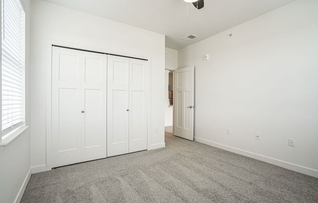 a bedroom with two closets and a door to the bathroom at Meadowbrooke Apartment Homes, Michigan, 49512