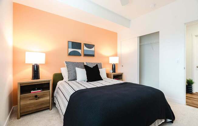 A bedroom with a bed, nightstands, and lamps.