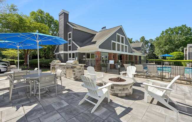A patio with a table and chairs and a blue umbrella.