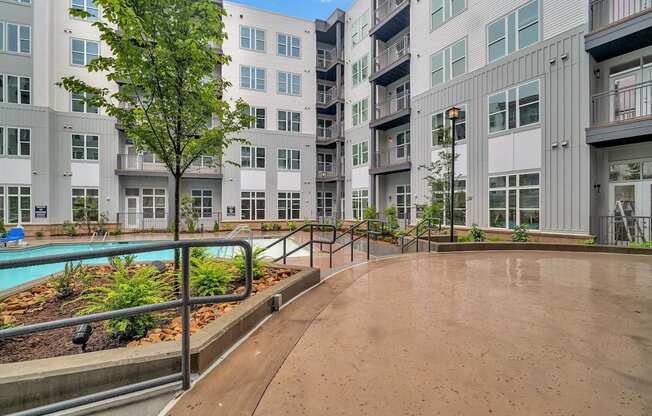 an empty courtyard with an apartment building and a pool