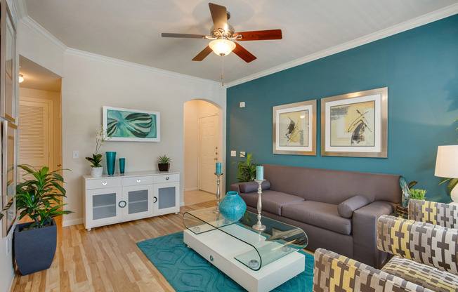 View of Living Room with Ceiling Fan, Plank Wood Flooring, and Entrance at Raveneaux Apartments