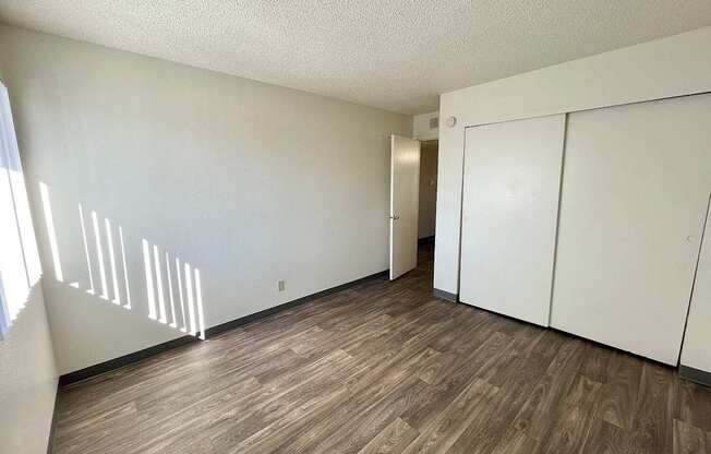 A room with wooden flooring and white walls.
