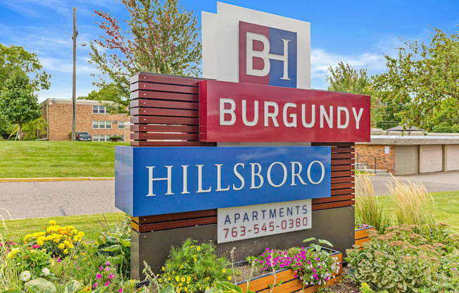 A sign for Burgundy Hillsboro Apartments with a phone number on it.