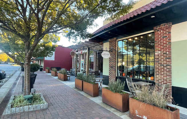 A tree is next to a building with a red roof.