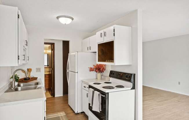 a kitchen with white cabinets and a stove and a sink