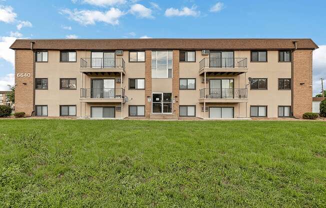 a large apartment building with green grass in front of it